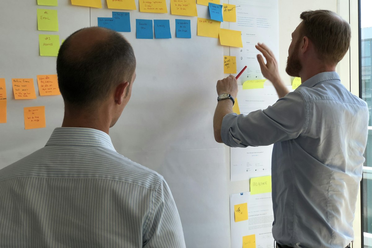 An analyst mapping requirements on a wall of sticky notes