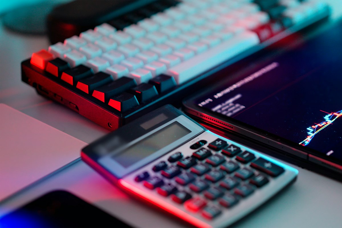 A calculator, keyboard and figures on a tablet at a desk