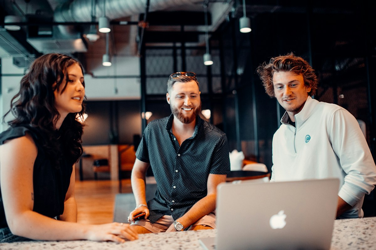 Colleagues gathered around a laptop in an office