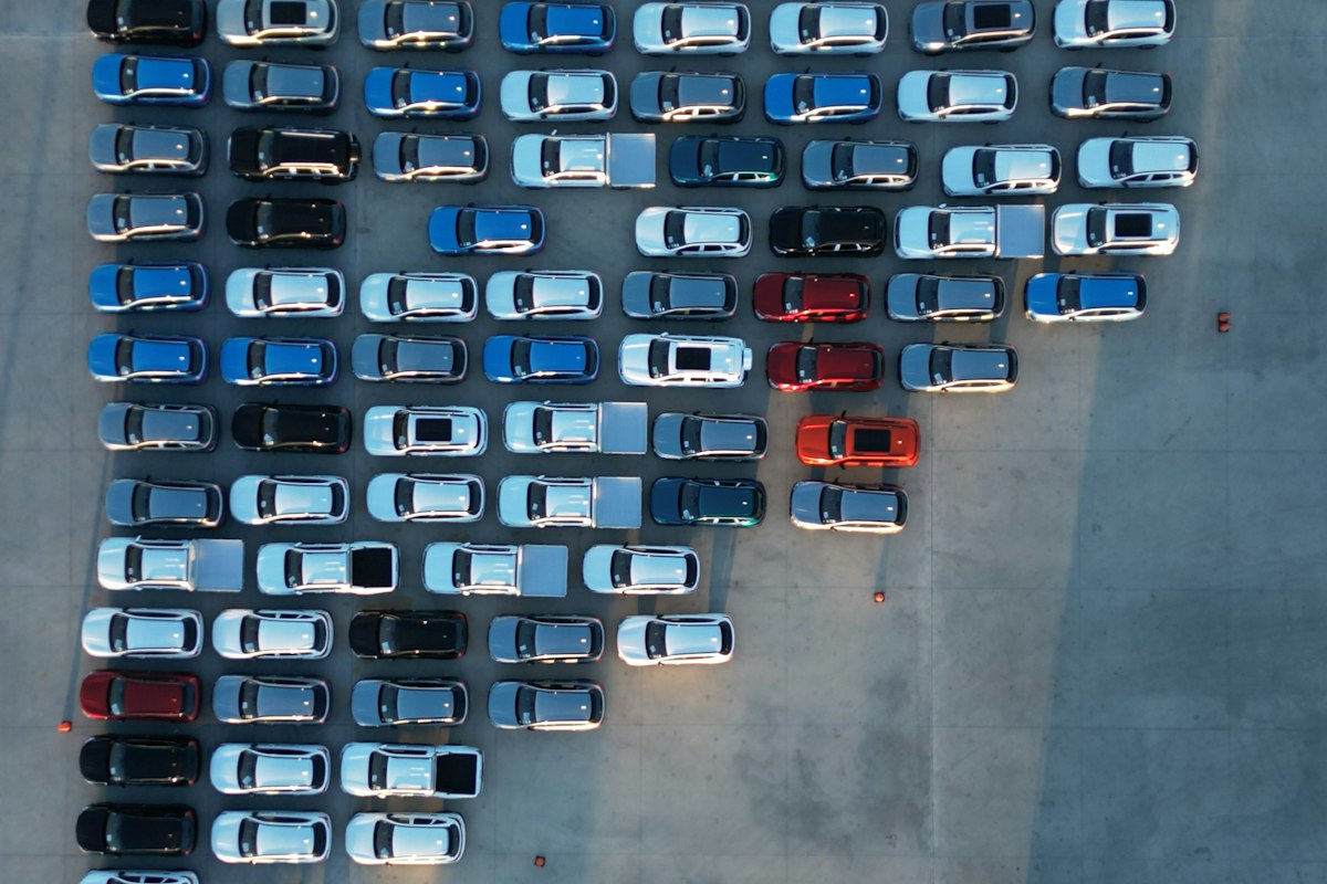Rows of new vehicles in a distribution lot, seen from above